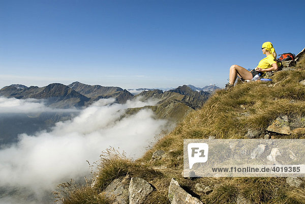 Frau sitzt am Gipfel des Deneck  Schladminger Tauern  St. Nikolei  Steiermark  Österreich  Europa