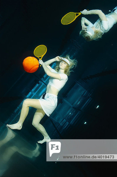 Frau spielt Tennis unter Wasser
