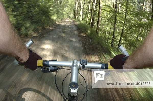 Mit dem Mountainbike fahren  Hände an Lenker  Waldweg