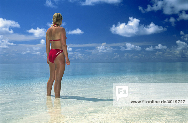 Woman  20 year-old  looking out over the ocean to the horizon  Summer Island Village  North Male Atoll  Maldives  Indian Ocean
