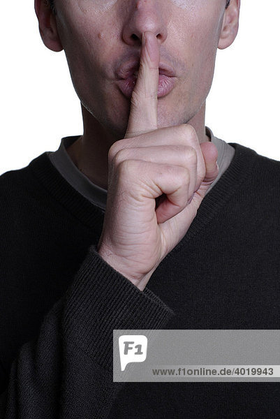 Man holding his finger to his mouth  asking for silence