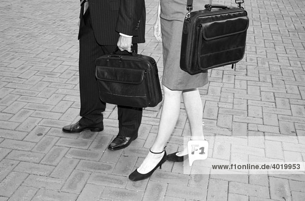 Business people carrying laptop bags  legs  black and white photo