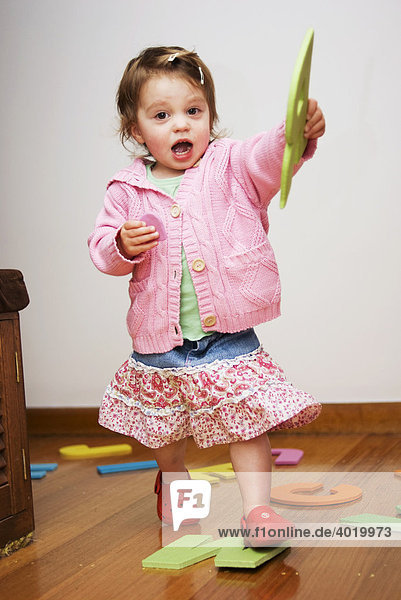 Mädchen  2 Jahre alt  spielt mit großen Buchstaben aus Schaumstoff