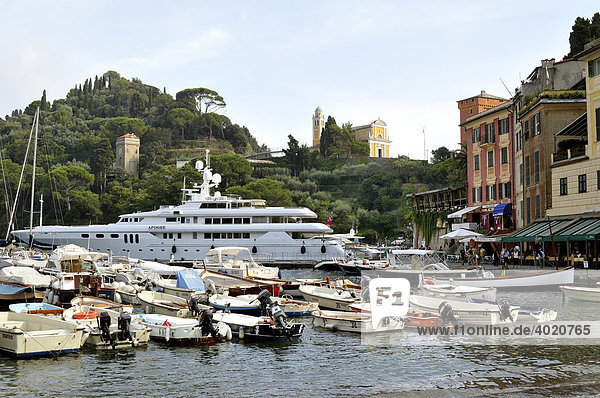Blick auf Luxusjacht im Naturhafen von Portofino und Kirche San Giorgio  Riviera di Levante  Italien  Europa