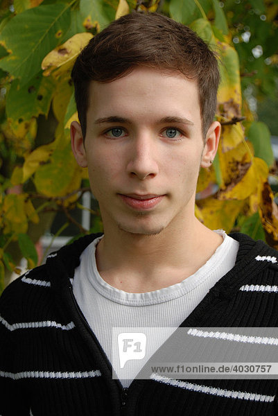 Teenager in front of autumnal chestnut tree  portrait
