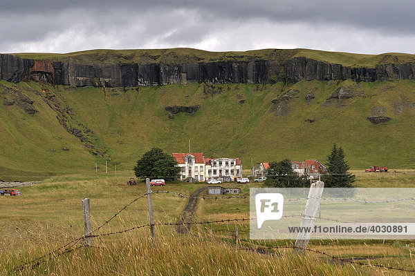 Deserted farm in front of a steep cliff  South Coast  Iceland  Europe
