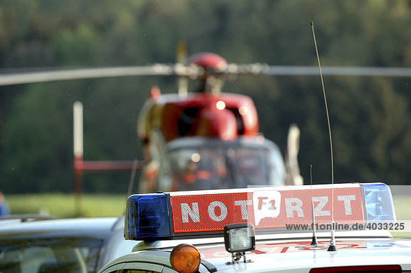 Illuminated sign Emergency Doctor on a rescue vehicle in front of a helicopter of the DRF or German Air Rescue Frickenhausen Baden-Wuerttemberg Germany
