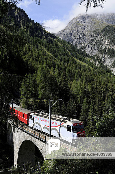 Train of the Rhaetische Bahn RhB Railway travelling on the Albula stretch between Berguen and Preda on a viaduct  Graubuenden  Switzerland  Europe