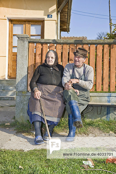 Rumänisches Paar sitzt auf einer Bank vor ihrem Haus  Cernuc  Salaj  Siebenbürgen  Transsilvanien  Rumänien  Europa