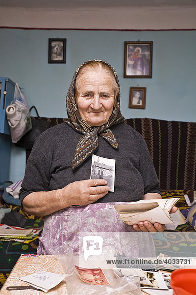 Rumänische Frau mit Kopftuch zeigt ihr Fotoalbum  Bezded  Salaj  Siebenbürgen  Transsilvanien  Rumänien  Europa