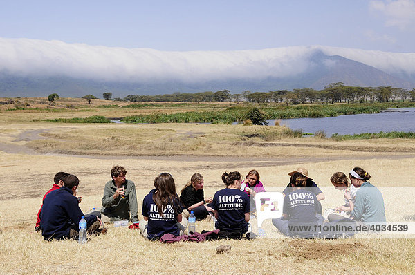 Tourists picnicing in front of the cloud covered edge of the Ngorongoro-crater  Ngorongoro Conservation Area  Tanzania  Africa