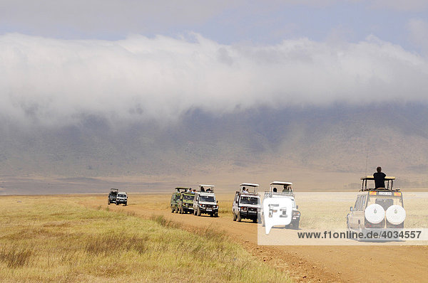 Tourists in several four-wheel-drive vehicles during wildlife observation  Ngorongoro-crater  Ngorongoro Conservation Area  Tanzania  Africa