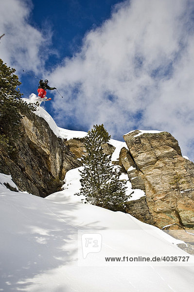 Tiefschnee Skifahrer  Freerider  beim Sprung über Felswand