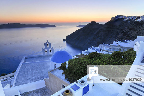 Stairway leading down to a white Greek church with a blue dome and a bell tower at sunset  Firostefani  Santorini  Cyclades  Greece  Europe