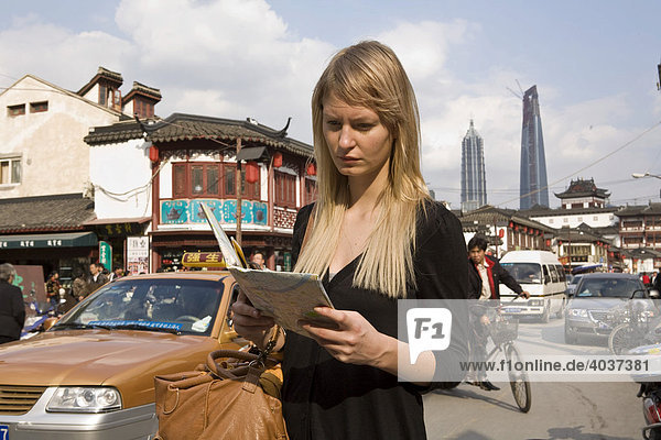 Junge Frau liest Karte  Shanghai  China  Asien