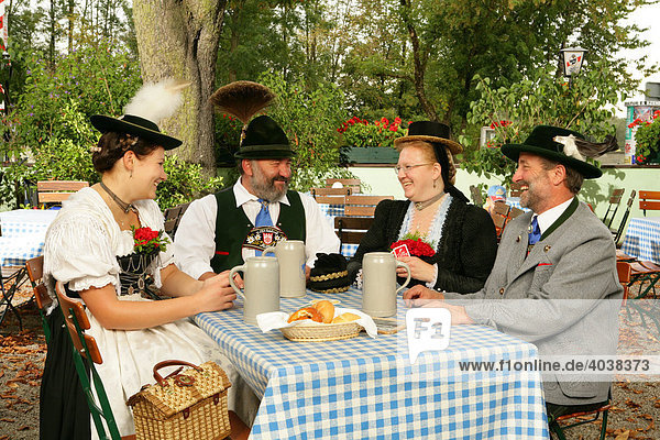 People wearing traditional costume in a beer garden  Muehldorf am Inn  Upper Bavaria  Germany  Europe