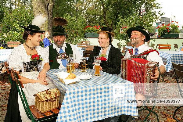 People wearing traditional costume in a beer garden  Muehldorf am Inn  Upper Bavaria  Germany  Europe