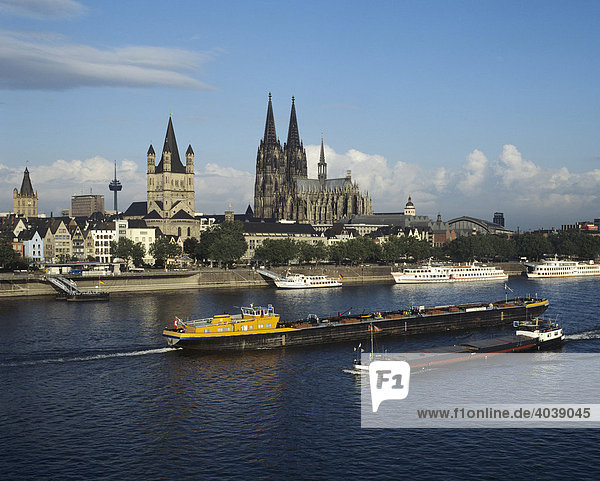 View over the Rhine River to the Cathedral and the Gross St. Martin Church  at front are freight barges and tourists boats of the Weisse Flotte  Cologne  North Rhine-Westphalia  Germany  Europe