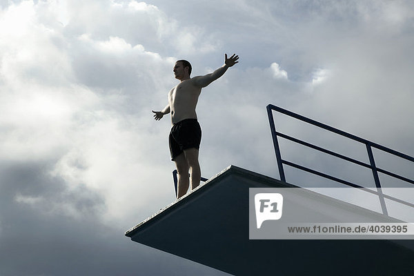 Junger Mann steht auf einem Sprungturm