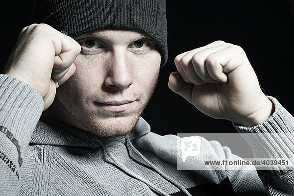 Young man wearing a beanie  ready for a fistfight