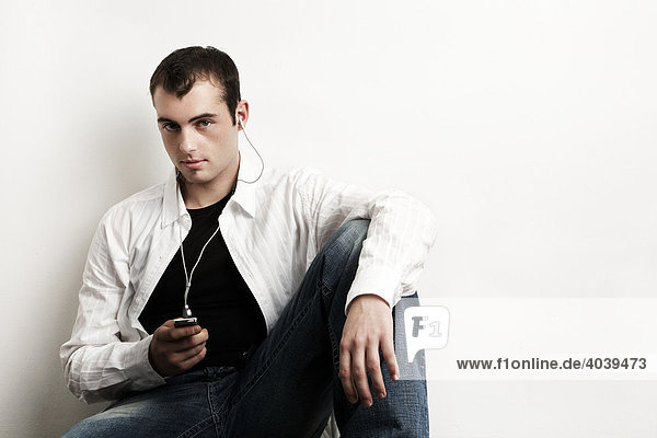Young man listening to music with his MP3 player