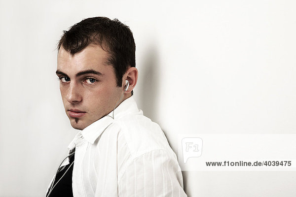 Young man listening to music with earphones  portrait