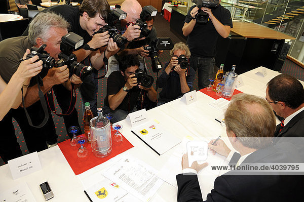 Dr. Wolfgang Schuster  mayor of Stuttgart  and Erwin Staudt  president of the VfB Stuttgart  surrounded by press photographers while signing the contract to change Gottlieb Daimler Stadium Stuttgart to the Mercedes-Benz Arena