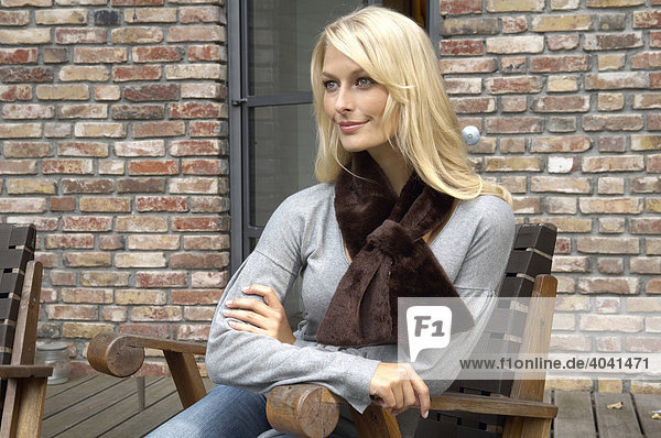 Portrait einer schönen blonden Frau mit Kunstpelzschal im Außenbereich