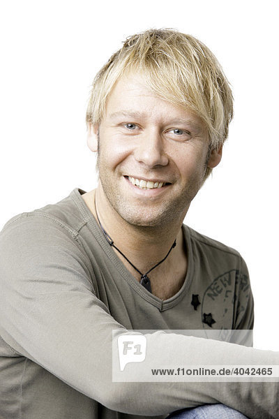 Blonde man wearing a T-shirt  looking into the camera  smiling  portrait