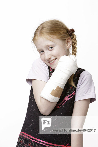 8-jähriges Mädchen zeigt ihren Gips-Arm  lacht