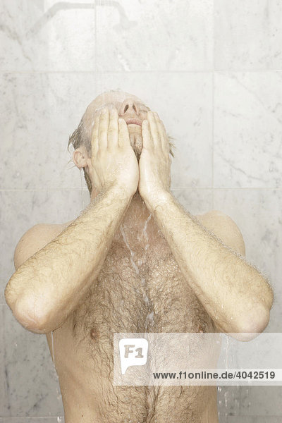 A man with chest hair is having a shower