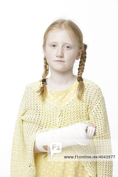 8-jähriges Mädchen mit Haarzöpfen und gebrochenem Arm in Gips