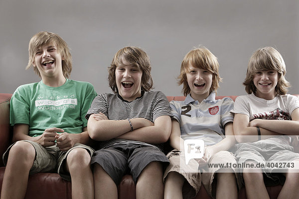 4 Jungen auf einem Sofa  lachen
