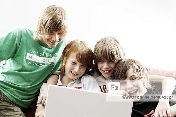 Vier Jungen spielen am Laptop