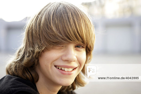 12-jähriger Junge mit blonden Haaren  lacht