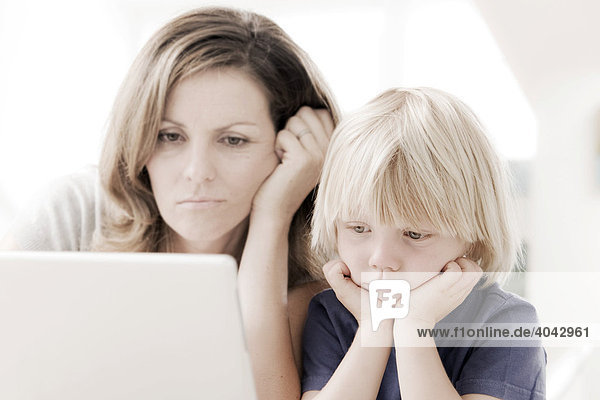 Mutter mit Sohn am Laptop  genervt