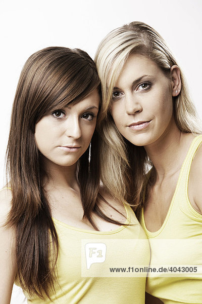 Two young woman  a blond and brunette  wearing yellow tops