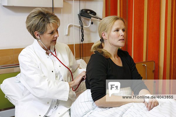 Ärztin untersucht eine Patientin am Krankenbett im Krankenhaus