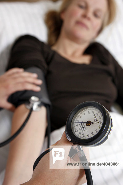 Blutdruck einer Patientin im Krankenhaus wird gemessen