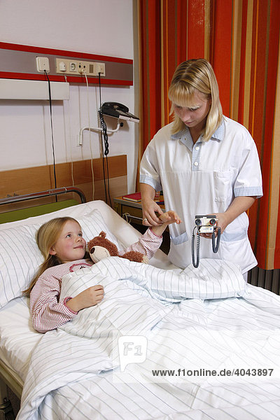 Krankenschwester fühlt den Puls einer jungen Patientin  7 Jahre  im Krankenhaus