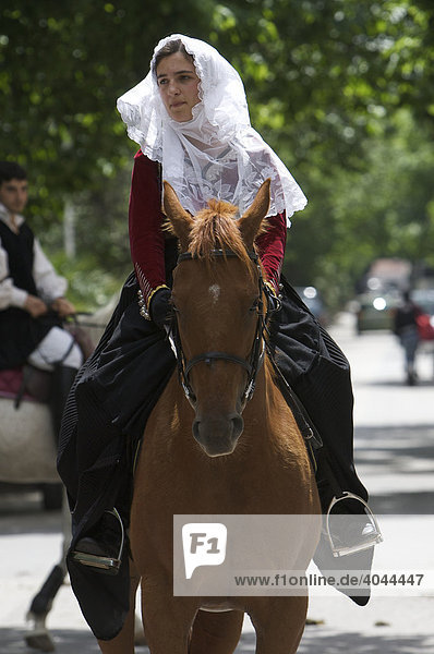 Young woman riding a horse wearing a traditional costume at the Cavalcata Sarda parade in Sassari  Sardinia  Italy  Europe