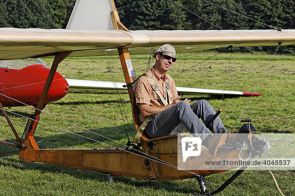Pilot sitting on the open seat of a historic glider waiting for take-off  glider to train beginners from 1938  wooden construction SG 38  Glider Airport  Aero Club Duesseldorf  Nordrhein-Westfalen  Germany  Europe