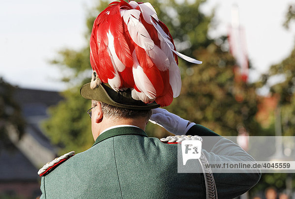 Schütze in Uniform mit rotweißem Federhut  salutiert  Rückenansicht  Schützenumzug in Xanten  Niederrhein  Nordrhein-Westfalen  Deutschland  Europa