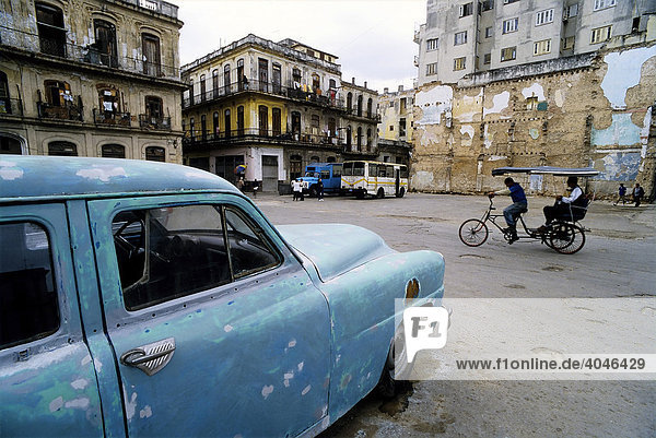 Fahrradrikscha überquert Platz mit baufälligen Häusern und US-Oldtimer  Centro Habana  Havanna  Kuba  Karibik