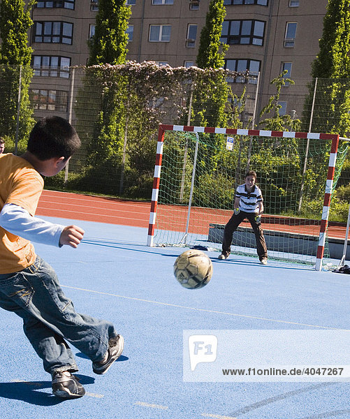 Kinder beim Fußballspiel auf einem Bolzplatz in Berlin Mitte  Berlin  Deutschland  Europa