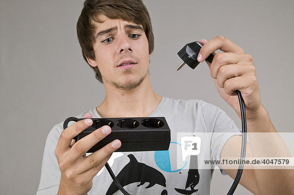 Young man with an extension cable