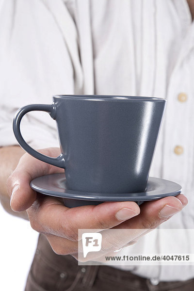 Mann hält graue Kaffeetasse