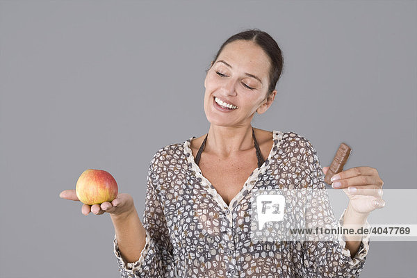 Woman with an apple and a chocolate snack