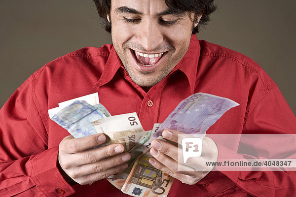 Young man pleased about his Euro banknotes