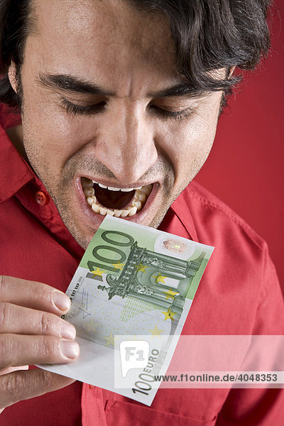 Man biting into a 100 Euro bill